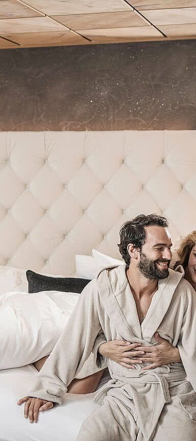 Paar sitz auf einem gemütlichen Bett im STOCK resort