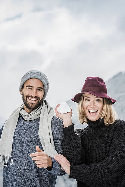 Paar beim Schneeball werfen im Luxushotel Zillertal STOCK resort